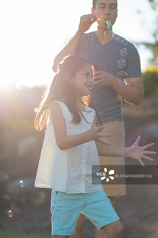 父亲和女儿在阳光下玩耍图片素材
