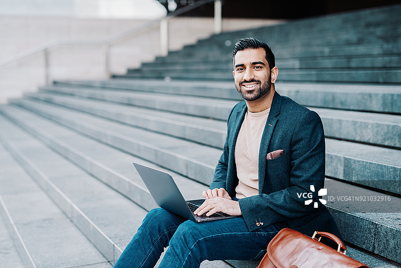 在公共场所使用免费Wi-Fi的印度男子图片素材