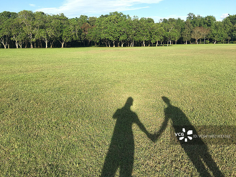 公园里情侣牵手的阴影，巴西立，新加坡图片素材