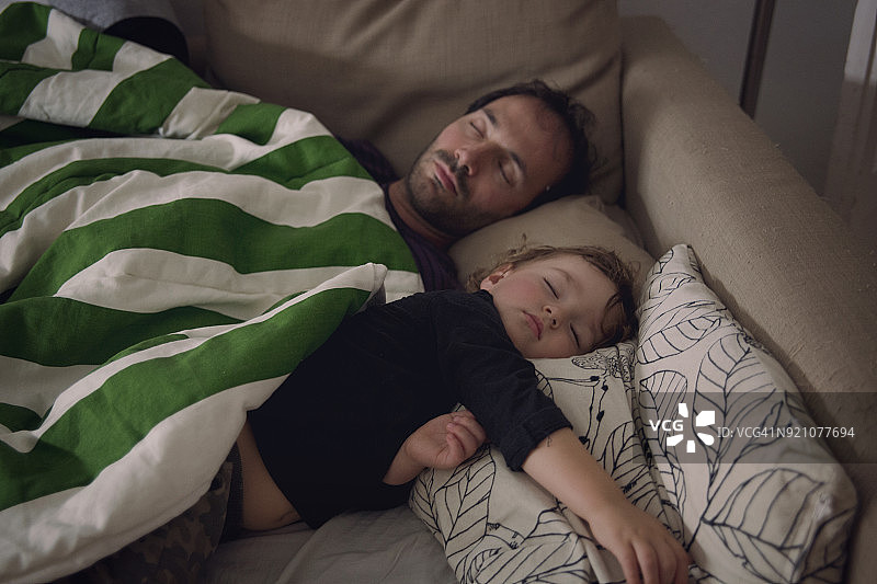 幼儿和爸爸在沙发上小憩图片素材