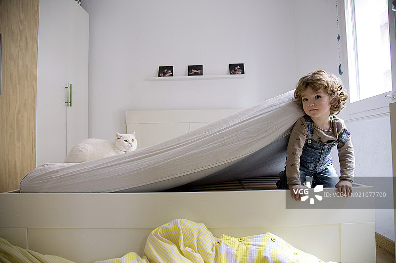 幼儿从床垫下钻出来图片素材