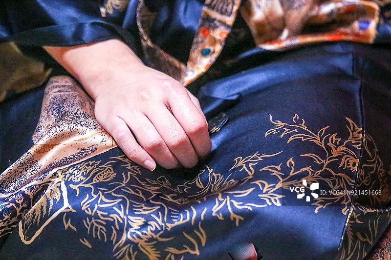 年轻女子丝绸礼服上的右手图片素材