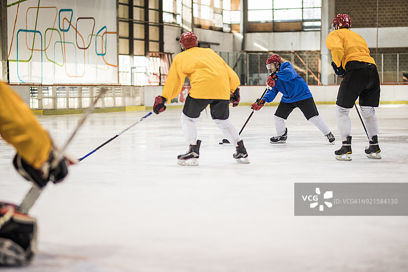 一群年轻男子在溜冰场上进行冰球比赛图片素材