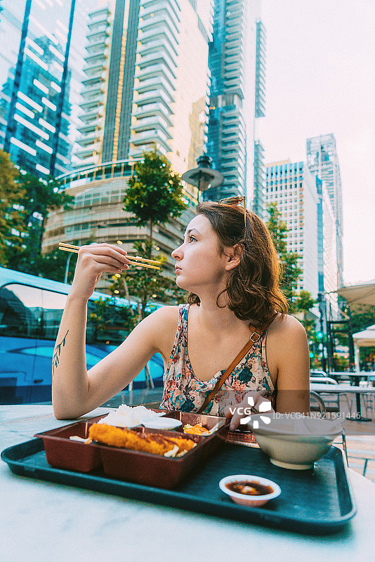 女人在新加坡老巴刹市场吃日本料理图片素材