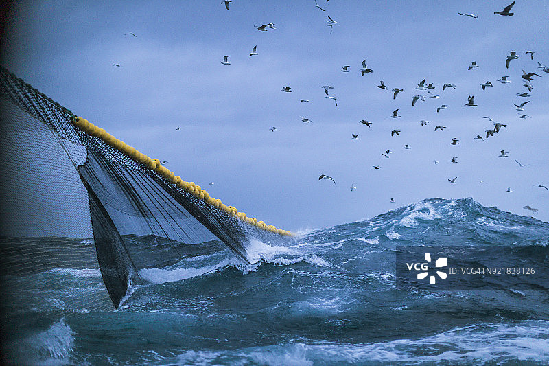 在波涛汹涌的大海上捕鱼的渔船图片素材