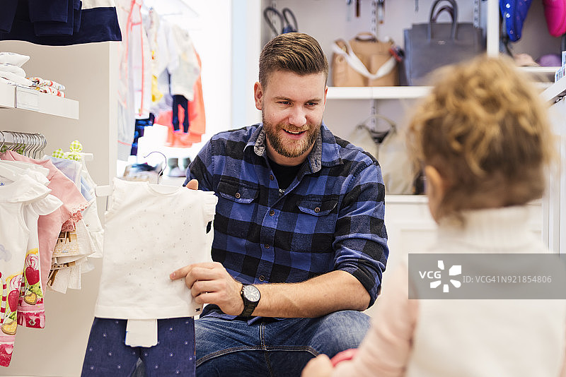 父亲在儿童商店和女儿一起购物图片素材