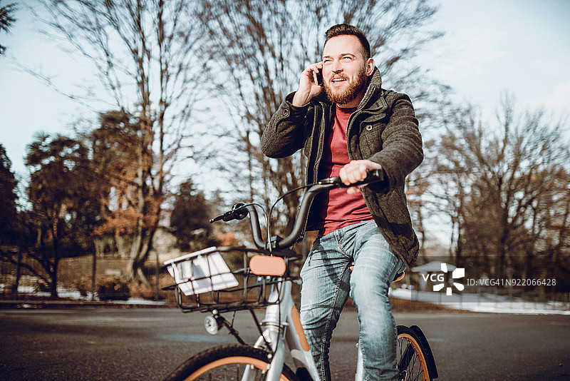 冬天，男孩骑自行车打电话图片素材
