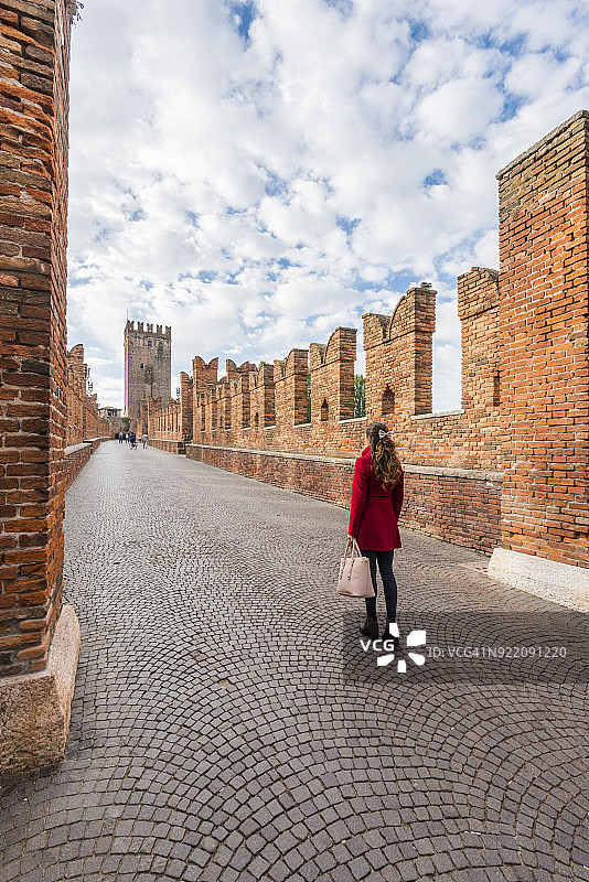在卡斯特维奇奥桥上行走的女人，意大利维罗纳图片素材