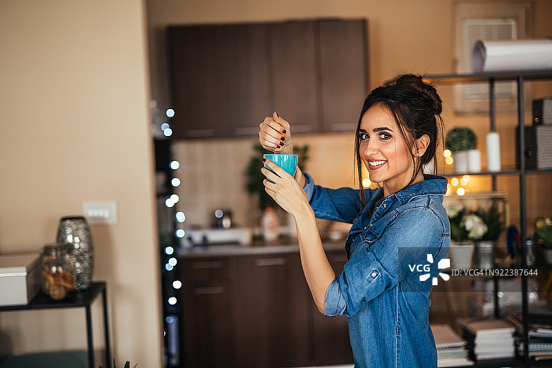 年轻女人在厨房榨橙汁图片素材
