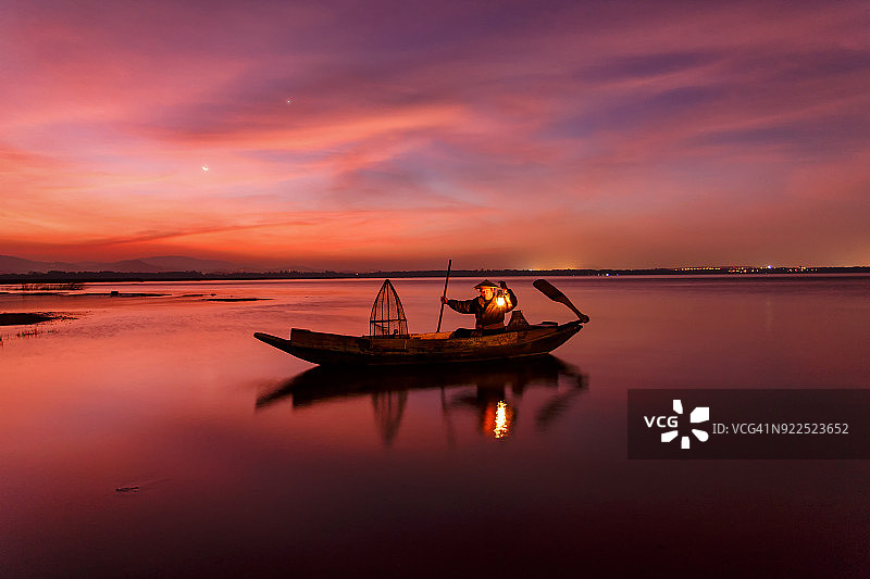 日落时分湖上的一位渔夫图片素材