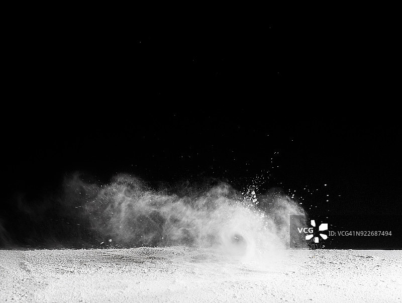 白色粉末粒子云在黑色背景上的爆炸效果图片素材