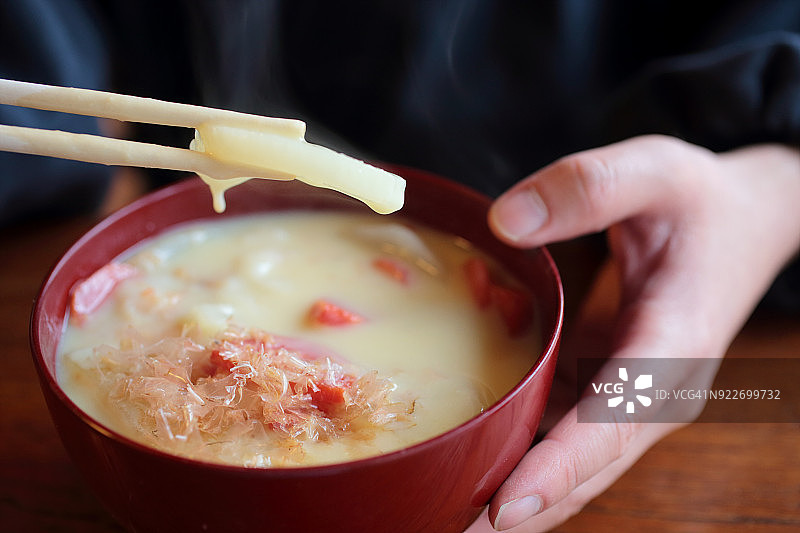 男人吃日本新年料理杂煮图片素材