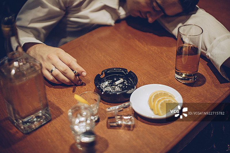 在酒吧柜台上睡觉的年轻醉酒男人图片素材