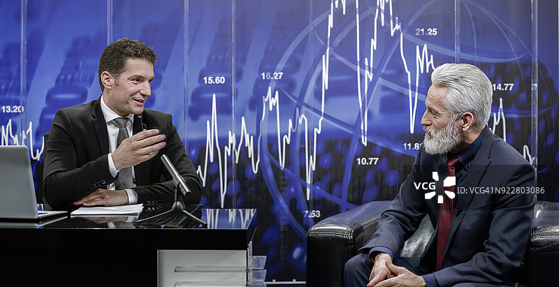 新闻播音员与商人对坐图片素材