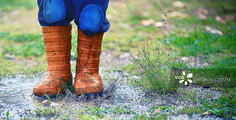 穿着黄色橡胶靴的孩子的腿图片素材