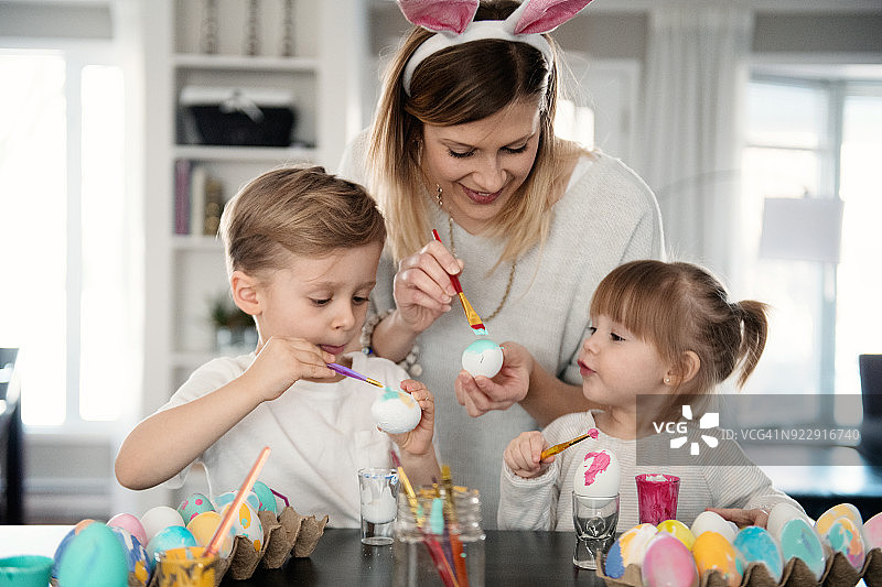 母亲和女儿、儿子一起画复活节彩蛋图片素材