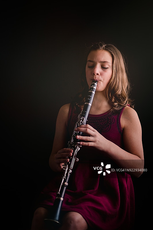 影棚人像：吹奏单簧管的女孩图片素材
