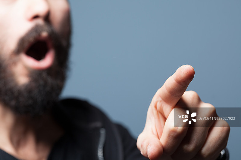 成年男人一边说话一边用手指指着图片素材