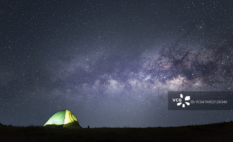 星空银河下的露营帐篷和手电筒人群图片素材