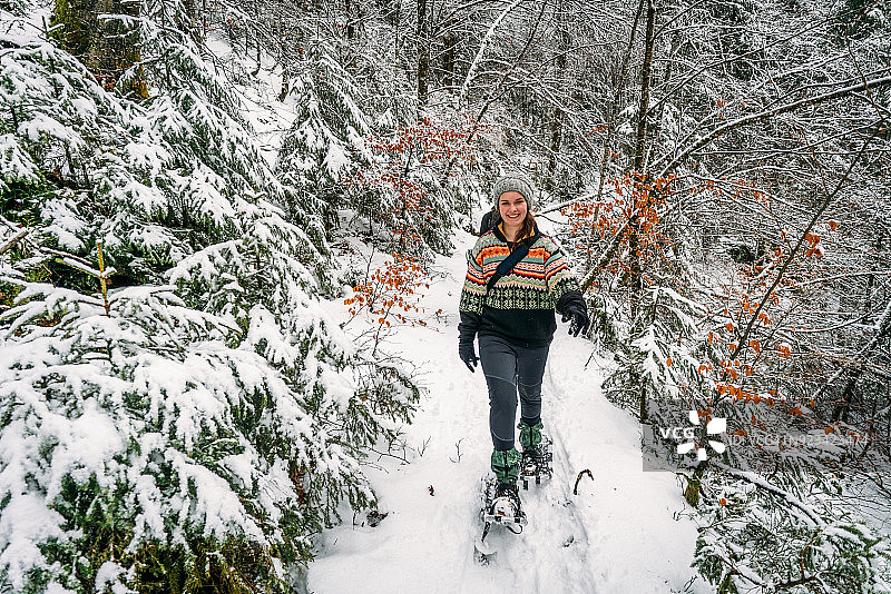穿雪鞋的年轻女人森林小径图片素材