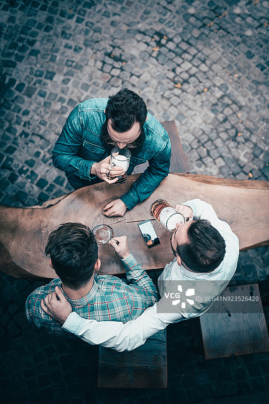 朋友在酒吧用啤酒祝酒的照片的俯视图图片素材
