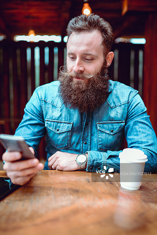 在咖啡馆发短信和喝咖啡的时尚人士图片素材