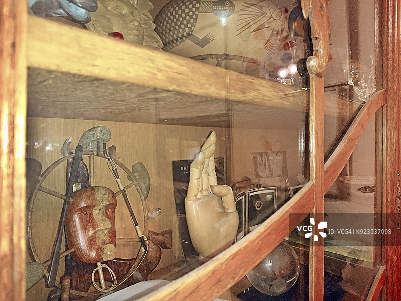 带人类手部复制品、土著面具和陶器的展示柜图片素材