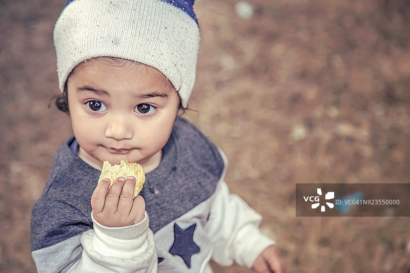 可爱的女宝宝在户外吃薯片图片素材
