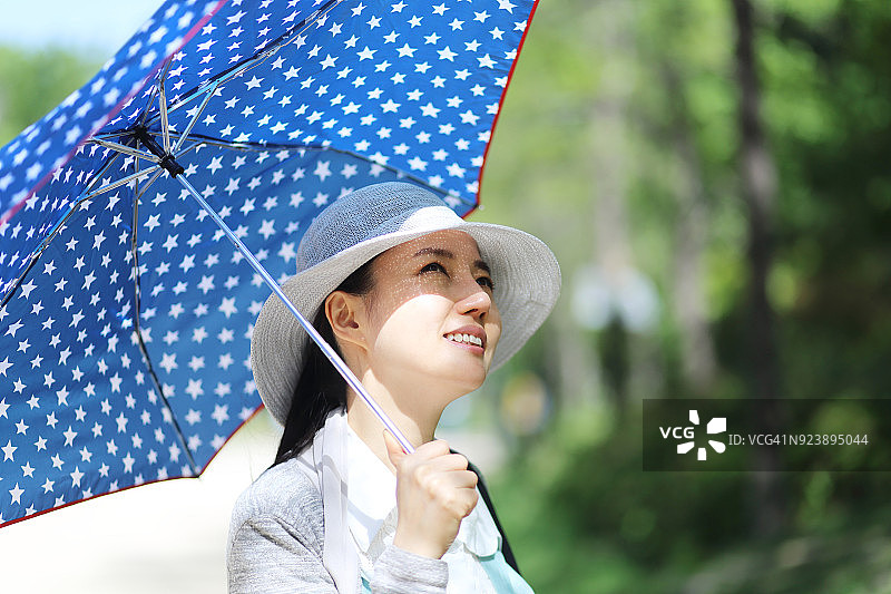 中年妇女在户外撑着阳伞图片素材