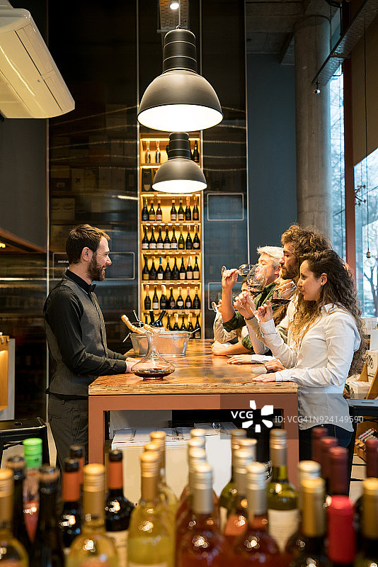 一群人在酿酒厂品酒，快乐的侍酒师在教他们图片素材
