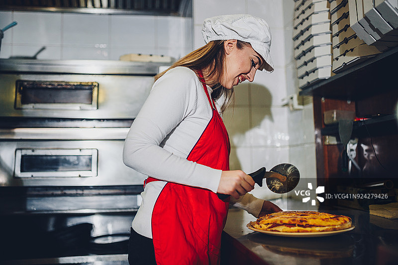 女人在餐厅厨房制作披萨图片素材