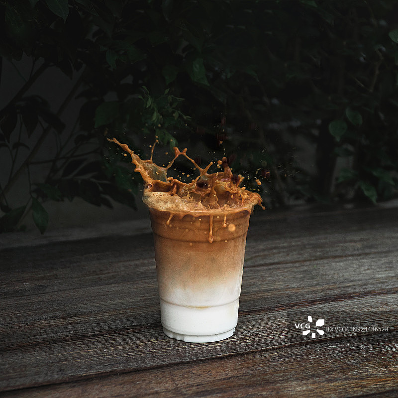 木桌上飞溅的冰咖啡图片素材