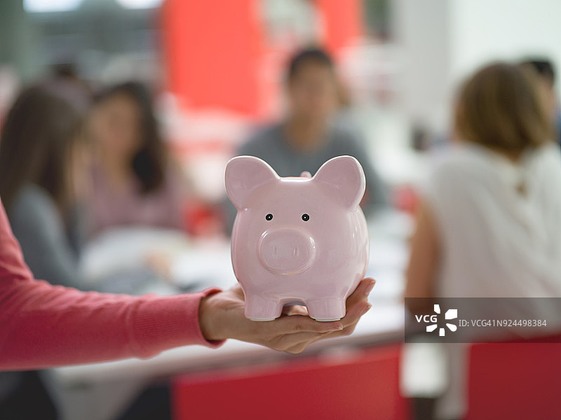无法辨认的女学生拿着存钱罐 - 学生贷款图片素材