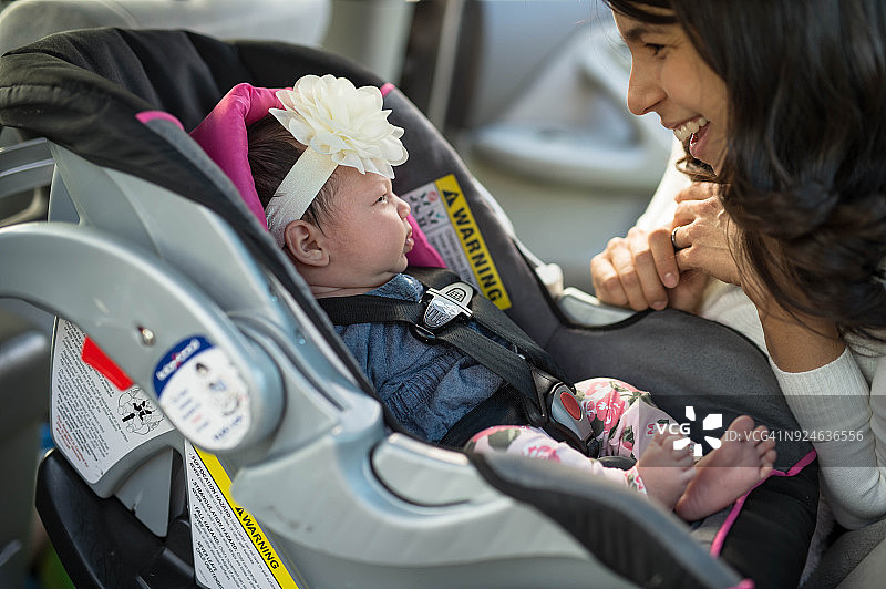 妈妈给婴儿系安全带图片素材