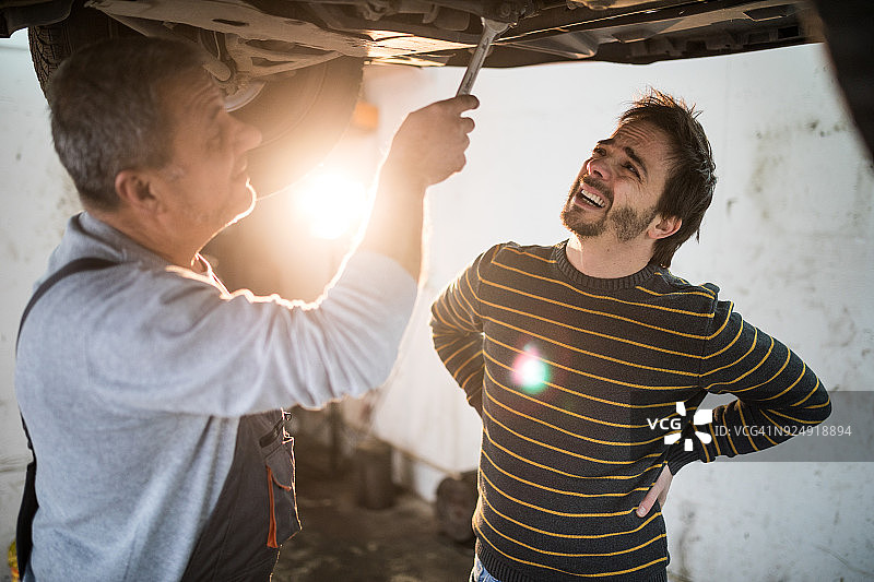 汽车修理工修车并与顾客交谈图片素材