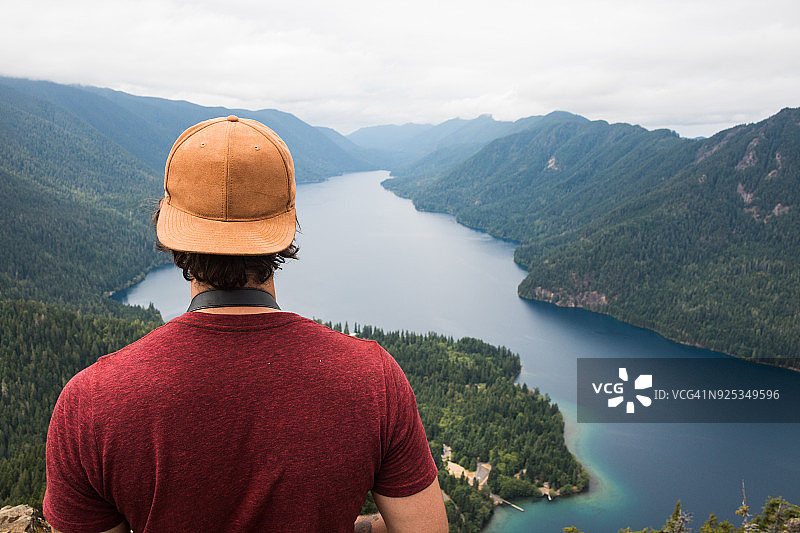 男人从山上眺望峡湾图片素材