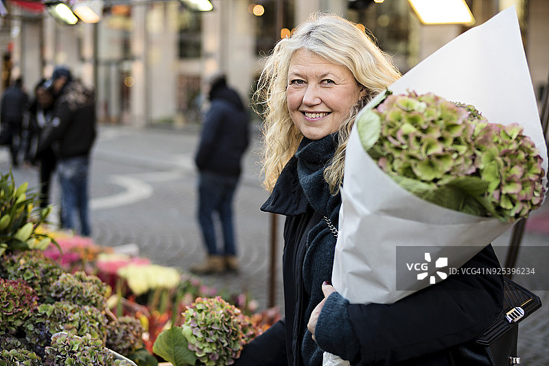 手捧鲜花的微笑女人图片素材