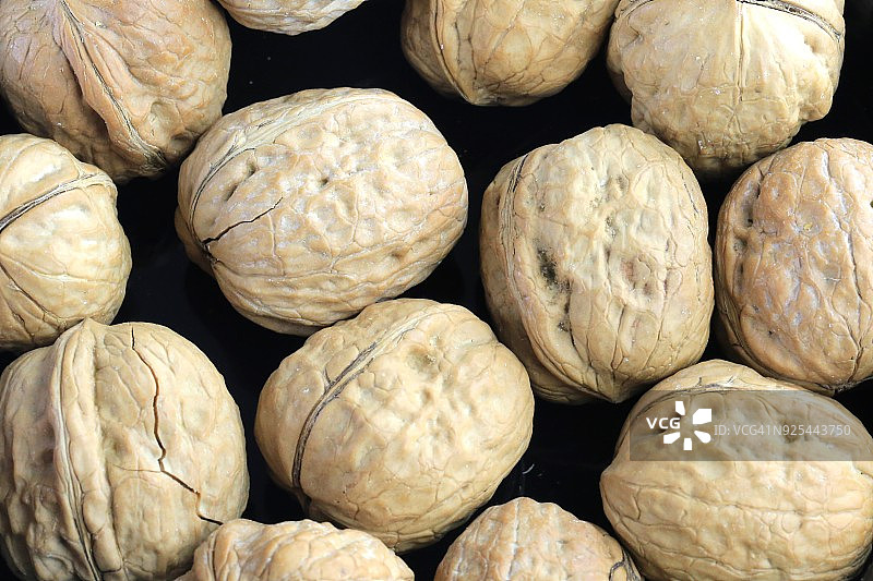 黑色背景下的英国核桃（胡桃属）图片素材