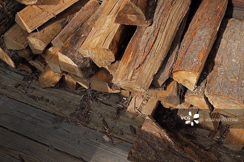 堆放在户外小木屋墙边的柴火图片素材