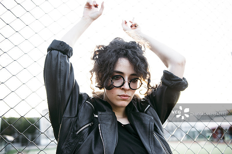 倚靠在链式围栏上沉思的白人妇女图片素材