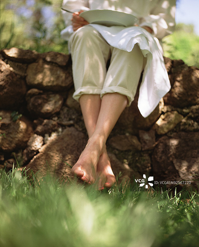 坐在石墙上吃东西的人图片素材