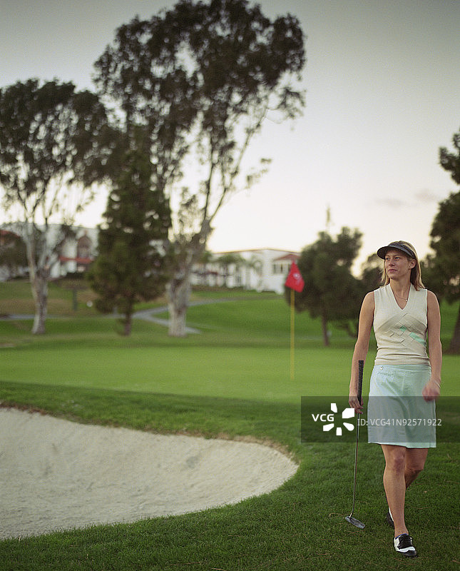 在高尔夫球场上的高尔夫球女运动员图片素材