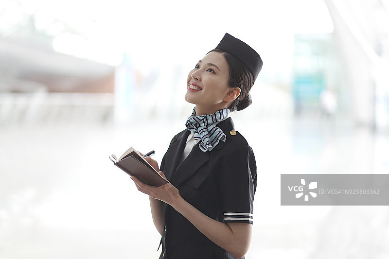 空姐在机场做笔记图片素材