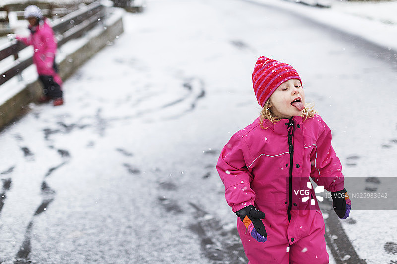 小女孩在户外吐舌头接雪花图片素材