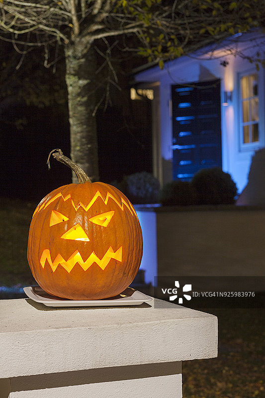 房子外桌子上内有灯光的万圣节南瓜图片素材