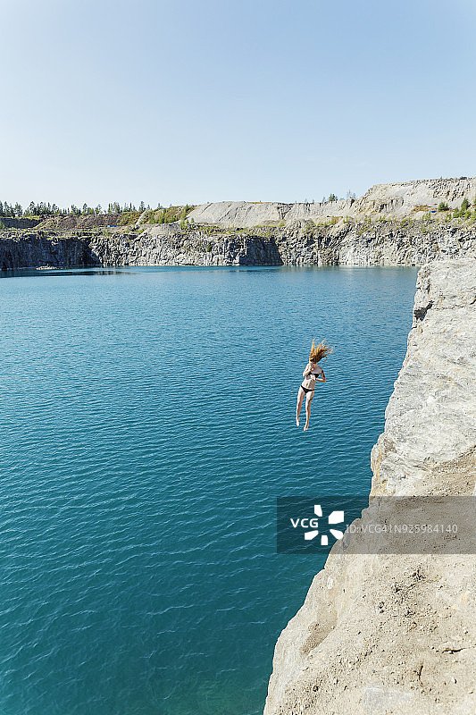 从悬崖跳入水中的女人图片素材