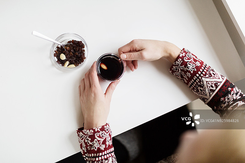 喝咖啡、吃葡萄干和坚果的妇女俯视图图片素材