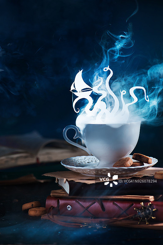 海怪：巨型章鱼在热气腾腾的茶杯中闪耀，梦想家或读者在咖啡和书籍中图片素材