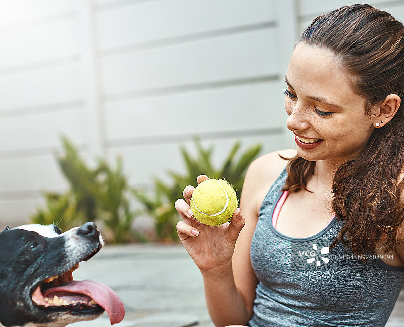漂亮的女孩看着她的宠物狗，面带微笑图片素材
