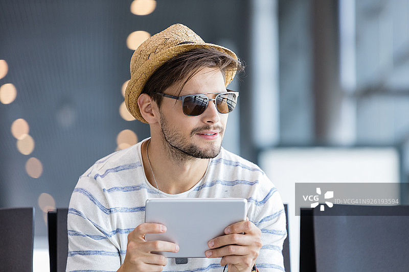 在机场休息室使用平板电脑的年轻英俊男子图片素材